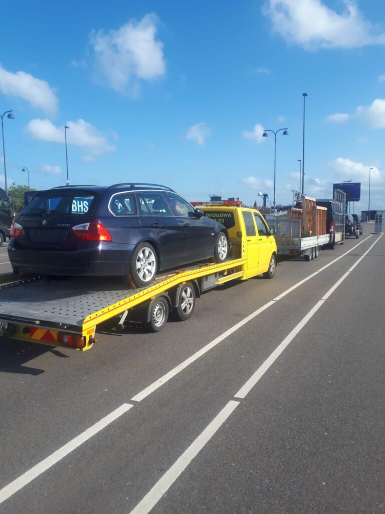 Laweta Wałcz transportująca uszkodzony pojazd po awarii na drodze.